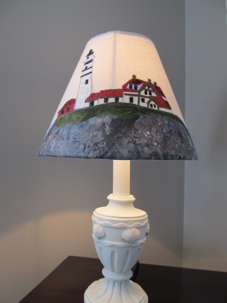 Table lamp with a handmade fabric lampshade showing Portland Head Light on its rocky point
